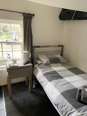 a bedroom with a bed and a table and a window at The Ram Inn in Brandon