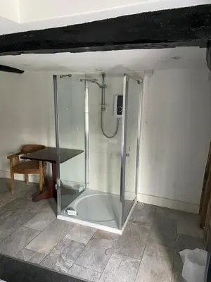 a glass shower in a room with a table at The Ram Inn in Brandon