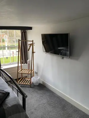 a bedroom with a flat screen tv on a wall at The Ram Inn in Brandon