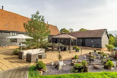 a backyard with a patio with furniture and plants at Doves Barn in Needham Market