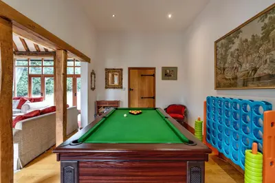 a living room with a pool table and a bed at Doves Barn in Needham Market