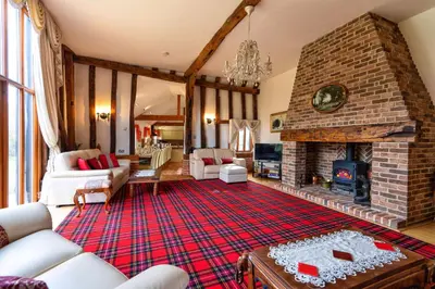 a living room with a large brick fireplace at Doves Barn in Needham Market