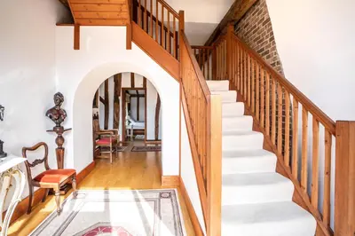 a staircase in a home with white walls and wooden floors at Doves Barn in Needham Market