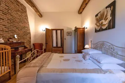 a bedroom with a large bed and a piano at Doves Barn in Needham Market