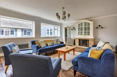 a living room with blue couches and a fireplace at Finest Retreats - The Stables at Crimplesham in Stradsett