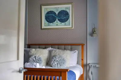 a bedroom with a bed with a picture on the wall at Finest Retreats - The Stables at Crimplesham in Stradsett