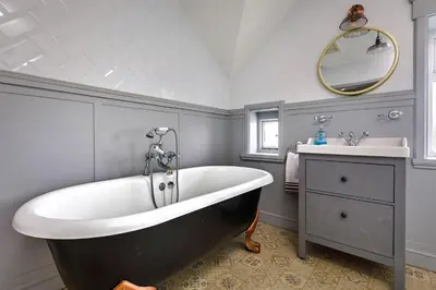 a bathroom with a large tub and a sink at Finest Retreats - The Stables at Crimplesham in Stradsett