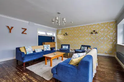 a living room with two blue couches and a table at Finest Retreats - The Stables at Crimplesham in Stradsett