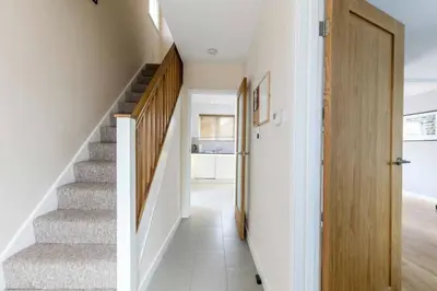 a staircase in a house with white walls at Spacious Modern Garden Family Home in Cambridge