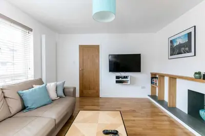 a living room with a couch and a fireplace at Spacious Modern Garden Family Home in Cambridge