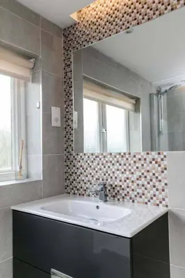 a bathroom with a sink and a mirror at Spacious Modern Garden Family Home in Cambridge