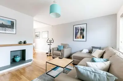 a living room with a couch and a fireplace at Spacious Modern Garden Family Home in Cambridge