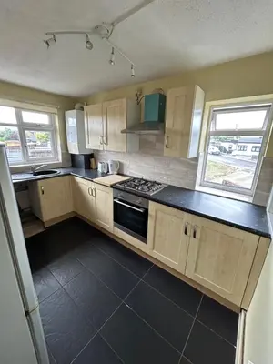 a kitchen with wooden cabinets and a stove top oven at 3 Bedroom Thundersley Apartment in Rayleigh