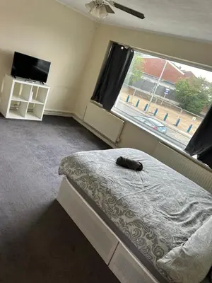 a bedroom with a bed and a large window at 3 Bedroom Thundersley Apartment in Rayleigh