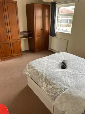 a bedroom with a bed with a cat laying on it at 3 Bedroom Thundersley Apartment in Rayleigh