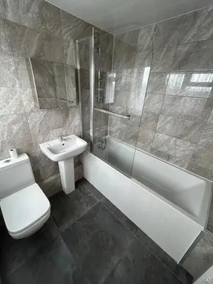 a bathroom with a toilet and a sink and a shower at 3 Bedroom Thundersley Apartment in Rayleigh
