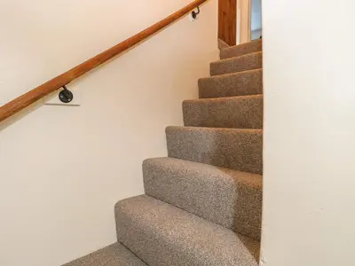 a staircase in a house with gray carpet at Rose Cottage in Stoke Ferry