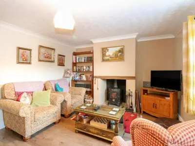a living room with two couches and a fireplace at Rose Cottage in Stoke Ferry