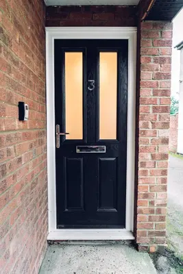 a black door on a brick house at Caroline Court - 1 Bedroom Apartment in Colchester