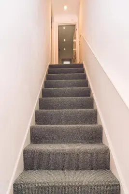 a staircase in a building with a gray carpet at Caroline Court - 1 Bedroom Apartment in Colchester
