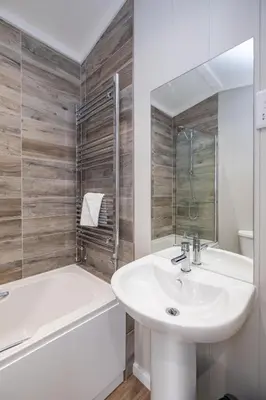 a white bathroom with a sink and a tub and a sink at Savannah Lodge - Aldeburgh Coastal Cottages in Sizewell