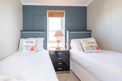 two beds sitting next to each other in a bedroom at Savannah Lodge - Aldeburgh Coastal Cottages in Sizewell