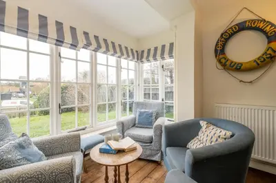 a living room with couches and chairs in front of a window at Sanctuary House in Thorpeness