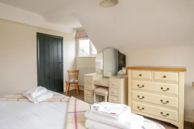 a bedroom with a bed and a dresser and a mirror at Sanctuary House in Thorpeness