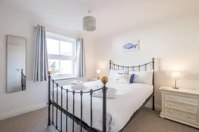 a bedroom with a bed and a window at April Cottage, Aldeburgh - Close to Aldeburgh beach and High Street - Managed by Aldeburgh Coastal Cottages in Aldeburgh