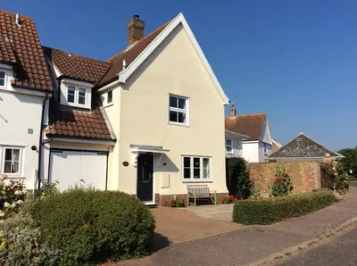 a white house with a black door at April Cottage, Aldeburgh - Close to Aldeburgh beach and High Street - Managed by Aldeburgh Coastal Cottages in Aldeburgh