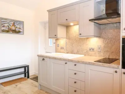 a kitchen with white cabinets and a sink at The Duck House in Thetford