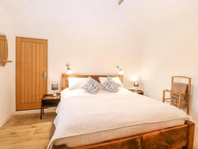 a bedroom with a large white bed with two pillows at The Duck House in Thetford
