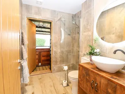a bathroom with a sink and a toilet and a mirror at The Duck House in Thetford