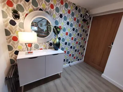 a room with a mirror and a white dresser with a lamp at The Barn in Swaffham