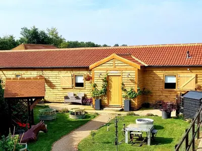 a small wooden house with a table and a fence at Mac Shack Cottage - Uk32376 in Ovington