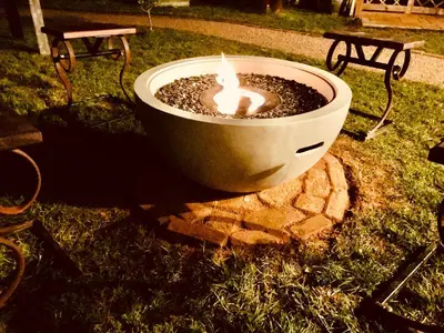 a fire pit in the grass with a candle in it at Mac Shack Cottage - Uk32376 in Ovington