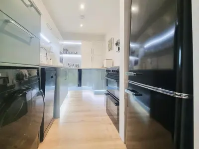 a kitchen with black appliances and a wooden floor at Mac Shack Cottage - Uk32376 in Ovington