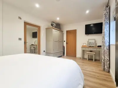 a bedroom with a bed and a tv on the wall at Mac Shack Cottage - Uk32376 in Ovington