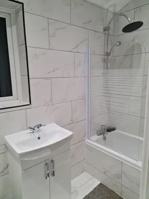 a white bathroom with a sink and a shower at Berrygate in Ipswich
