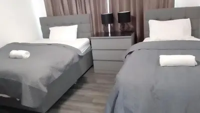 a bedroom with two beds with white pillows at Berrygate in Ipswich