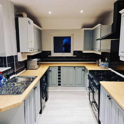a kitchen with blue cabinets and a sink at Berrygate in Ipswich