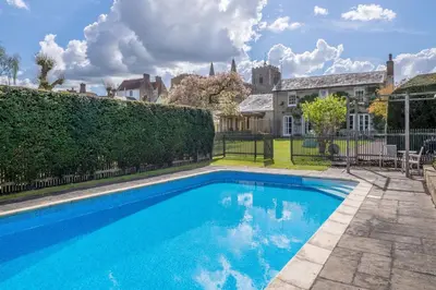 a swimming pool in the yard of a house at Gothic House Cottage in Clare
