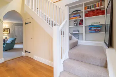 a staircase in a home with bookshelves at Gothic House Cottage in Clare