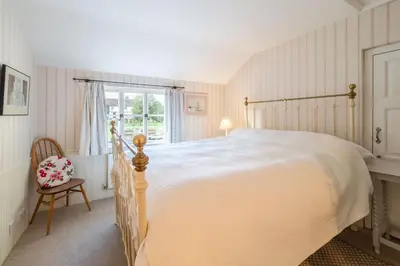 a bedroom with a large bed and a window at Gothic House Cottage in Clare