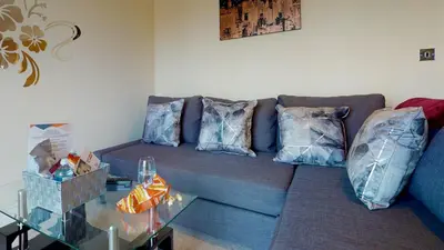 a living room with a blue couch with pillows on it at Niche Water Tower Apartments in Braintree