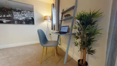 a room with a desk with a laptop and a chair at Niche Water Tower Apartments in Braintree