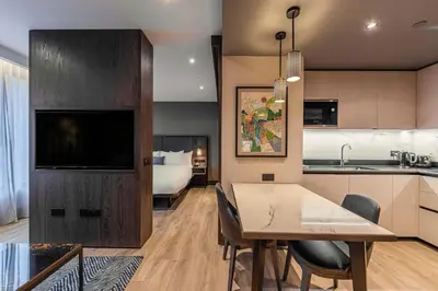 a kitchen and dining room with a table and a television at The Fellows House Cambridge, Curio Collection By Hilton in Cambridge