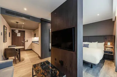 a hotel room with a bed and a television at The Fellows House Cambridge, Curio Collection By Hilton in Cambridge