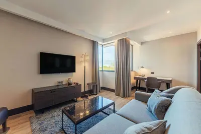 a living room with a couch and a flat screen tv at The Fellows House Cambridge, Curio Collection By Hilton in Cambridge