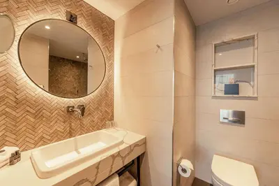 a bathroom with a sink and a mirror at The Fellows House Cambridge, Curio Collection By Hilton in Cambridge